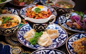 una mesa con platos de comida azul y blanco en YOKUB Guest House, en Samarkand