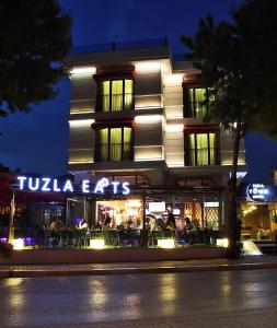 a building with a sign that reads tula eats at night at Tuzla Town Hotel in Tuzla