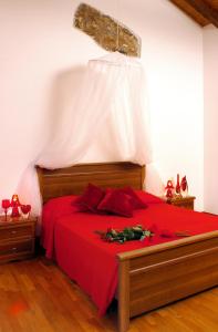a bedroom with a red bed with red pillows at Tenuta Valdomini in Attimis