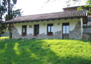 uma pequena casa com um jardim relvado em frente em Tenuta Valdomini em Attimis