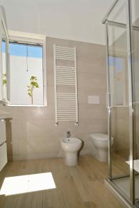 een badkamer met toilet en glazen douche bij Altomare Case Vacanza in Porto Cesareo