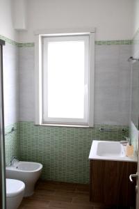 a bathroom with a tub and a sink and a window at Altomare Case Vacanza in Torre Lapillo