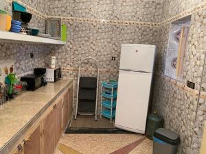 a kitchen with a white refrigerator in a room at Quiet Apartment in El Ksiba / Beni Mellal in El Ksiba