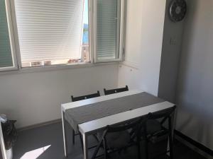 - une table et des chaises blanches dans une chambre avec 2 fenêtres dans l'établissement Apartment Riva, à Tivat
