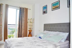 a bedroom with a large bed with a window at Unit 1109 Cityscape Residences in Bacolod +35 photos
