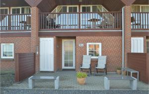 a brick building with two chairs and a balcony at Lovely Home In Rømø With House Sea View in Kongsmark +24 photos
