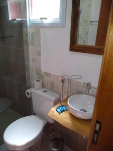uma casa de banho com um WC branco e um lavatório. em Chalés Recanto Moinho em Toledo