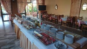 a buffet line with plates and food on a table at Poseidon Hotel in Amoudara Herakliou