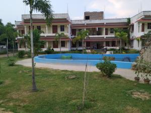 um edifício com piscina em frente a um edifício em Bhalobasa Anandabas em Bolpur