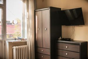une chambre avec une commode et une grande armoire avec une télévision dans l'établissement Valentine Apartment, à Lviv