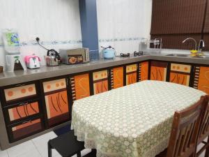 a kitchen with a table and a counter top at Rose Condo@ Cocobay Beach Resort in Port Dickson