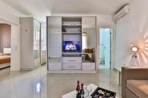 a living room with a tv and a couch at Zelen LUX in Sutomore