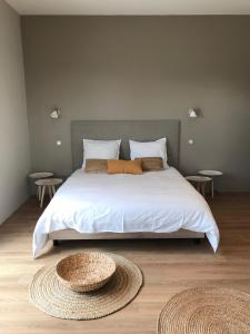 1 dormitorio con 1 cama blanca grande y 2 mesas en Le Domaine du Cade-Gîtes d'exception 4étoiles "La Villa du Cade", en Cazevieille