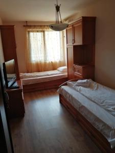 a small bedroom with two beds and a window at Apartment Lake Tryavna in Tryavna