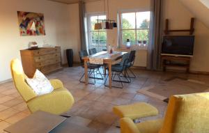 sala de estar con mesa, sillas y TV en Ferienwohnung Rheinblick Bislich en Wesel