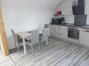 een keuken met een tafel en stoelen in een kamer bij Hohenlohe -Residenz-Svetlana in Langenburg