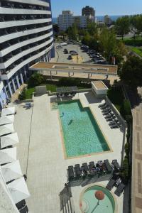 una vista aérea de una piscina con sillas y un edificio en Ruby Red & Atlantic Blue Apartments in Oceano Atlantico, en Portimão