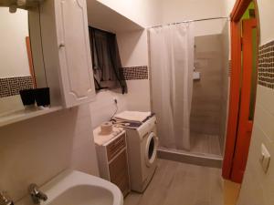 y baño con lavabo y lavadora. en Casa Vacanza Il Leonpardo, en Tuscania