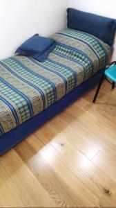 1 cama con marco azul en una habitación con suelo de madera en Casetta ad Ispica, en Ispica