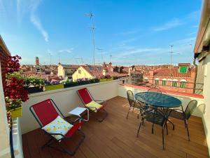 balcón con mesa, sillas y vistas a la ciudad en Ca’ degli Oresi en Venecia