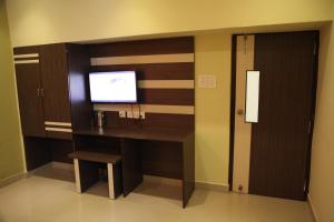 a room with a desk and a tv on a wall at Hotel Everest in Hyderabad