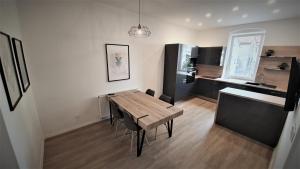 a kitchen and dining room with a wooden table and chairs at Jacob´s Apartement in Pilsen