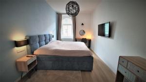 a bedroom with a bed with a blue couch at Jacob´s Apartement in Pilsen