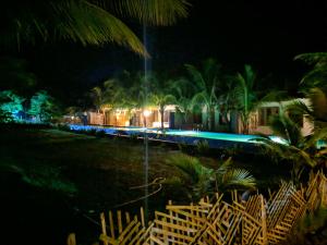 un tren con luces azules en las vías por la noche en Mermaid Beach Resort en Dhoāpālong