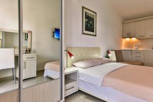 a small bedroom with a bed and a kitchen at Zelen LUX in Sutomore