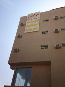 a building with a sign on the side of it at مراحل للشقق المخدومة الخرج 1 in Al Kharj