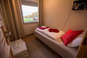 Habitación pequeña con cama y ventana en Hestasport Apartment, en Varmahlid