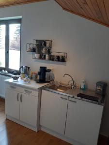 a kitchen with white cabinets and a counter top at B&B Circuitez-vous in Stavelot