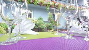 a table with wine glasses on a purple and green table cloth at Logis Hotel Aux Comtes De Hanau in Ingwiller