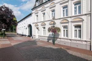 a large white building with flowers in the windows at B&B Laeve in de Brouwerie in Geleen