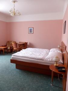 a bedroom with a bed and a dining room with a table at Penzion Harmonie in Chodov