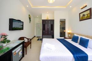 a hotel room with a bed and a television at Flame Flowers Homestay in Hoi An