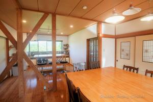 a room with a wooden table and a dining room at Powder Peaks Chalet in Akakura