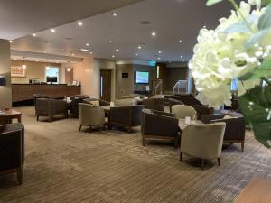 un vestíbulo del hotel con sillas, mesas y flores en Park Hotel, en Falkirk