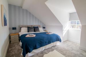 1 dormitorio con 1 cama grande con manta azul en 35 High Street Apartment, en Hawick