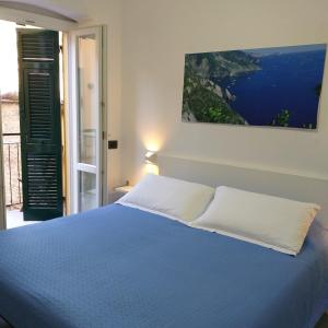 una camera con letto blu e vista sull'oceano di Il Patio a Manarola