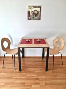 a table with two chairs and a table with two cups at Ferienwohnung Asal in Waldbronn