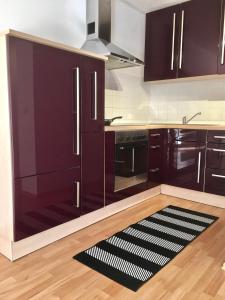 a kitchen with dark purple cabinets and a rug at Ferienwohnung Asal in Waldbronn