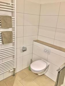 a white bathroom with a toilet and towels at Ferienwohnung Asal in Waldbronn