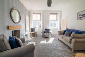 a living room with two couches and a mirror at 35 High Street Apartment in Hawick