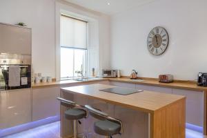 a kitchen with a counter and a clock on the wall at 35 High Street Apartment in Hawick