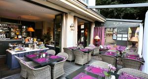 a restaurant with purple tables and chairs on a patio at La Place Boutique Hotel in Antibes +25 photos