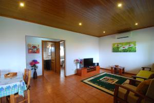 a living room with a table and a dining room at Alojamentos Flores Island in Faja Grande