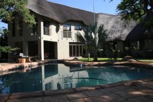 a house with a swimming pool in front of a building at Oryx B&B Reserved Guests Only in Mokopane
