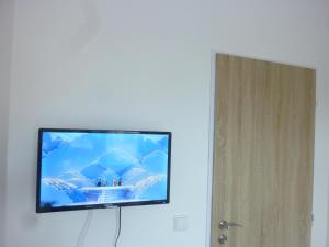 einen Flachbild-TV, der an einer weißen Wand hängt in der Unterkunft Apartmán VAN NG in Prag
