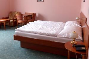 a bedroom with a bed and a table and chairs at Penzion Harmonie in Chodov
